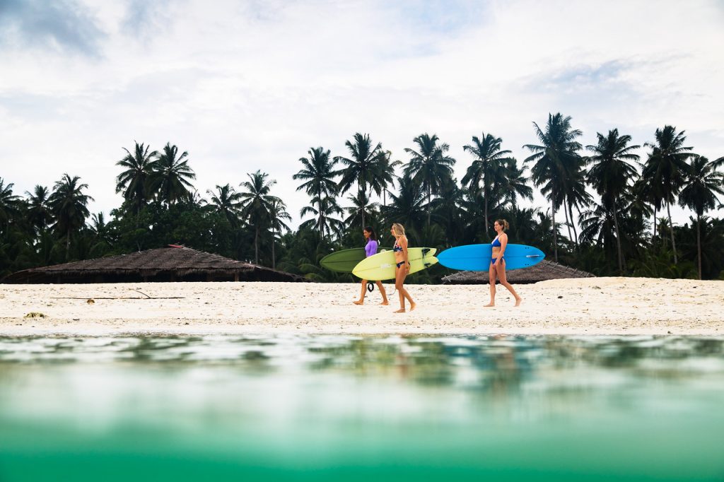 Surfers walking on the beach carrying their boards