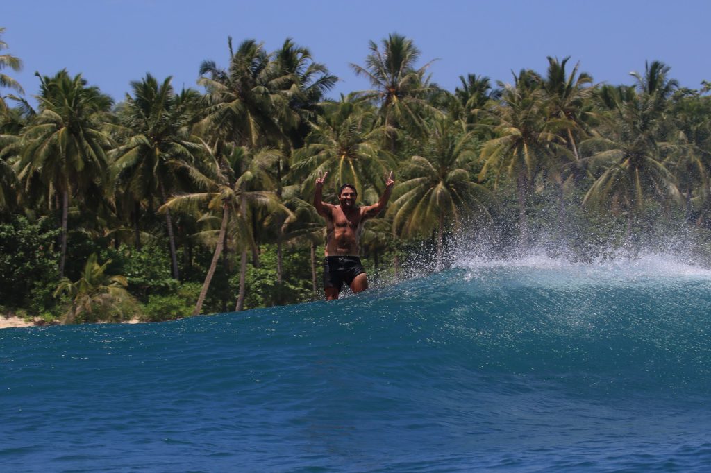 Surf coach and student celebrating together in the water