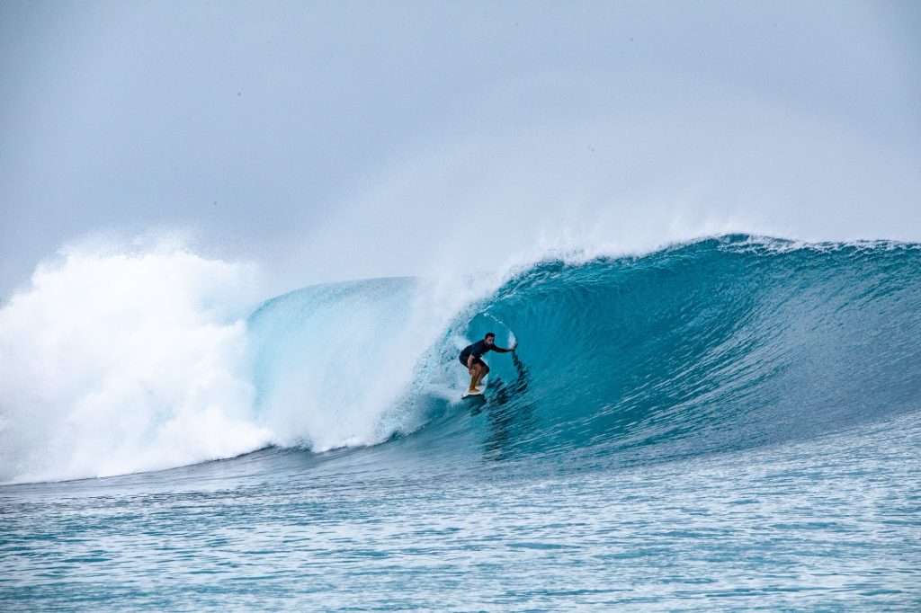 Surfer dropping into a hollow wave
